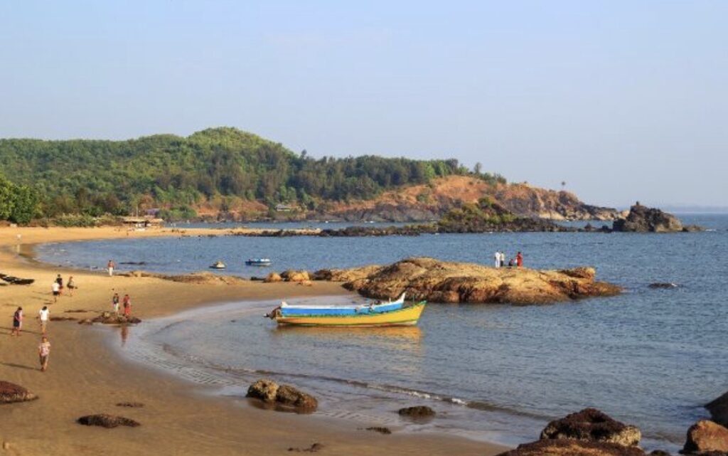Om Beach Gokarna with boats and rocky coastline

